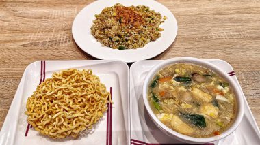 Lezzetli kızarmış pilav ve yağda kızartılmış kalın erişte tabağı ve kremalı çorba.