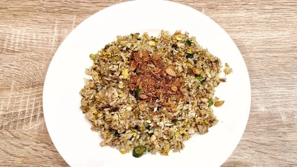 Beyaz tabakta servis edilen kızarmış soğanlı leziz pilavın yüksek açılı görüntüsü.