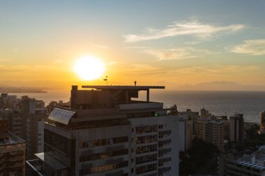 Çatıdaki Yalnızlık: Helipad 'da Şehir, Okyanus ve Altın Gün Batımına Bakan Adam