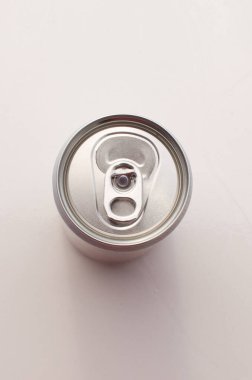 Gümüş soda kutusu, üst görünüm, etiketsiz. Parlak metalik doku ve ışık yansımaları..