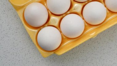 Sarı ambalajlı yumurtaların yakın plan görüntüsü. Hafif bir yüzeye yerleştirilmiş. Tazelik ve sadelik yayıyor..