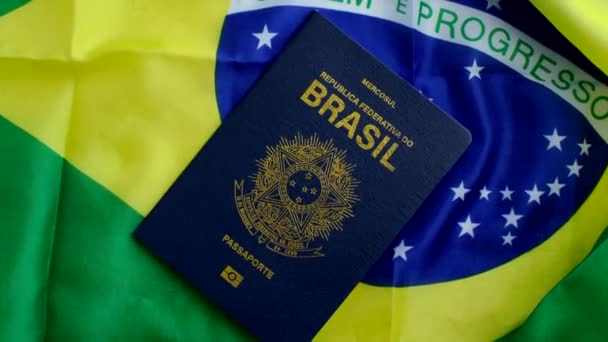 ハーモニーにおける国家のアイデンティティ 活気に満ちた国旗と調和したブラジルのパスポートは 市民権と国との連合を象徴しています — ストック動画