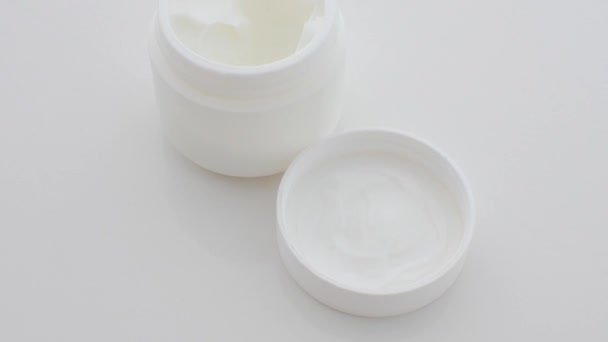ホワイト表面のクリーム瓶の詳細は パーソナルケア製品の美しさと優雅さを強調しています — ストック動画