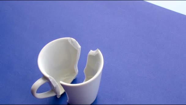 壊れた白い磁器のカップの詳細は 不完全に見つかった詩を象徴しています 壊れた白い磁器のコップのクローズアップ 光表面の脆弱性の物語を伝える — ストック動画