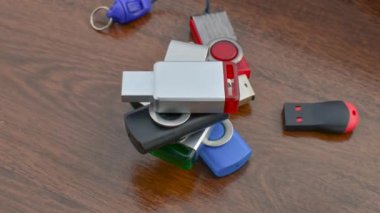 USB sürücüsü koleksiyonu, portatif teknolojinin çağdaş bir görüntüsü olan tahtaya yakın çekim yapıyor. USB sürücülerinin çeşitliliği ayrıntılı olarak, ahşap bir baz üzerinde depolama çözümleri sağlar.