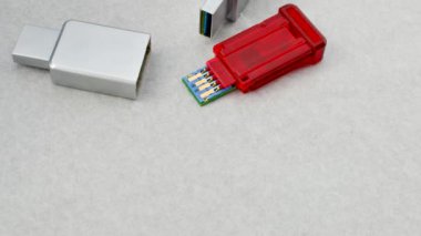 Parçalanmış USB flaş bellek odaklı, bileşenlerini açık bir zeminde gösteriyor. Parçalanmış bir USB flaş belleğin beyaz desenli bir yüzeyde detaylı görünümü, yapısını gösterir.
