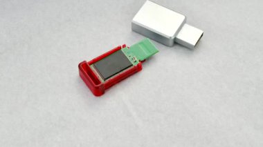Parçalanmış USB flaş bellek odaklı, bileşenlerini açık bir zeminde gösteriyor. Parçalanmış bir USB flaş belleğin beyaz desenli bir yüzeyde detaylı görünümü, yapısını gösterir.