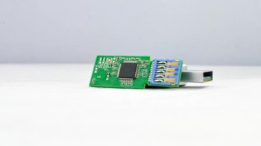 Parçalanmış USB flaş bellek odaklı, bileşenlerini açık bir zeminde gösteriyor. Parçalanmış bir USB flaş belleğin beyaz desenli bir yüzeyde detaylı görünümü, yapısını gösterir.