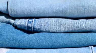 Rahat stil: katlanmış kot pantolonların yakın çekimi, gündelik moda projeleri için ideal. Katlanmış kot pantolon, kot pantolonun çok yönlülüğü ve konforu vurgulanıyor.