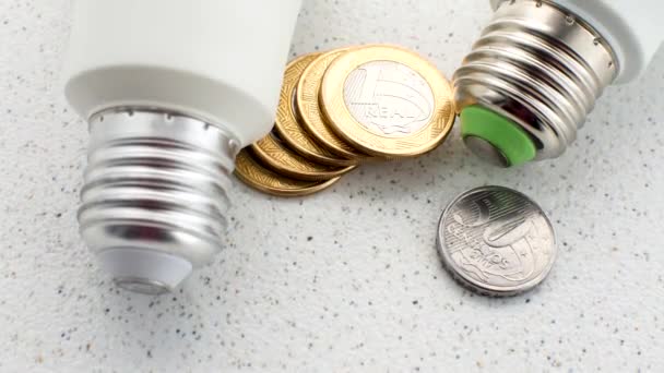 ランプの下のブラジル硬貨 電気代への財政的影響 照明の経済的観点を表す — ストック動画