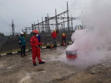 Banjarmasin, Endonezya. 6 Kasım 2021 'de erkekler yangın söndürücüyü kullanarak bir yangın söndürücüyü canlandırdı.