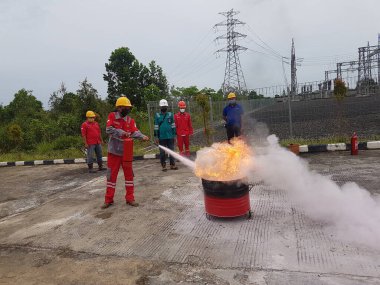 Banjarmasin, Endonezya. 6 Kasım 2021 'de erkekler yangın söndürücüyü kullanarak bir yangın söndürücüyü canlandırdı.