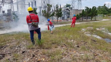 Banjarmasin, Endonezya. 6 Kasım 2021 'de erkekler yangın söndürücüyü kullanarak bir yangın söndürücüyü canlandırdı.