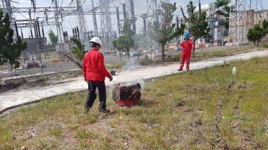 Banjarmasin, Endonezya. 6 Kasım 2021 'de erkekler yangın söndürücüyü kullanarak bir yangın söndürücüyü canlandırdı.