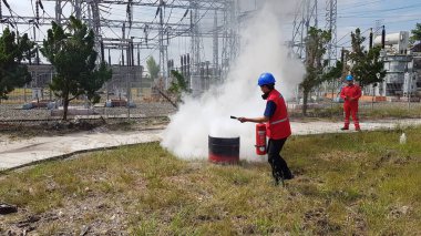 Banjarmasin, Endonezya. 6 Kasım 2021 'de erkekler yangın söndürücüyü kullanarak bir yangın söndürücüyü canlandırdı.