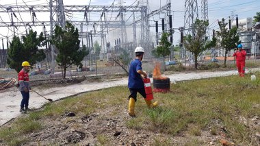 Banjarmasin, Endonezya. 6 Kasım 2021 'de erkekler yangın söndürücüyü kullanarak bir yangın söndürücüyü canlandırdı.