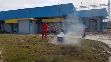 Banjarmasin, Endonezya. 6 Kasım 2021 'de erkekler yangın söndürücüyü kullanarak bir yangın söndürücüyü canlandırdı.