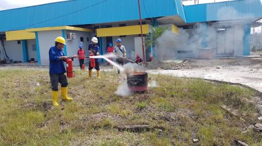 Banjarmasin, Endonezya. 6 Kasım 2021 'de erkekler yangın söndürücüyü kullanarak bir yangın söndürücüyü canlandırdı.