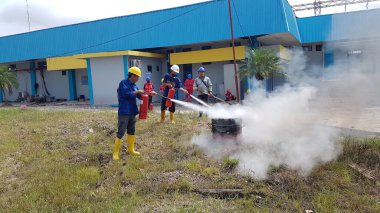 Banjarmasin, Endonezya. 6 Kasım 2021 'de erkekler yangın söndürücüyü kullanarak bir yangın söndürücüyü canlandırdı.