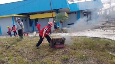 Banjarmasin, Endonezya. 6 Kasım 2021 'de erkekler yangın söndürücüyü kullanarak bir yangın söndürücüyü canlandırdı.
