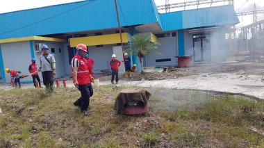 Banjarmasin, Endonezya. 6 Kasım 2021 'de erkekler yangın söndürücüyü kullanarak bir yangın söndürücüyü canlandırdı.