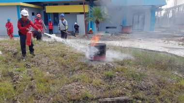 Banjarmasin, Endonezya. 6 Kasım 2021 'de erkekler yangın söndürücüyü kullanarak bir yangın söndürücüyü canlandırdı.