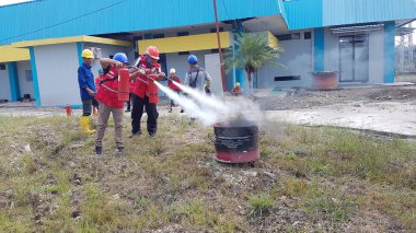 Banjarmasin, Endonezya. 6 Kasım 2021 'de erkekler yangın söndürücüyü kullanarak bir yangın söndürücüyü canlandırdı.