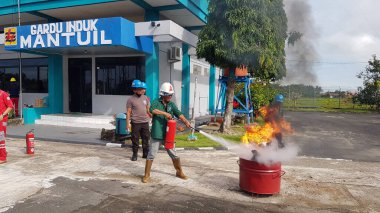 Banjarmasin, Endonezya. 6 Kasım 2021 'de erkekler yangın söndürücüyü kullanarak bir yangın söndürücüyü canlandırdı.