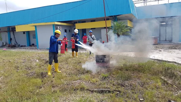 Banjarmasin, Endonezya. 6 Kasım 2021 'de erkekler yangın söndürücüyü kullanarak bir yangın söndürücüyü canlandırdı.