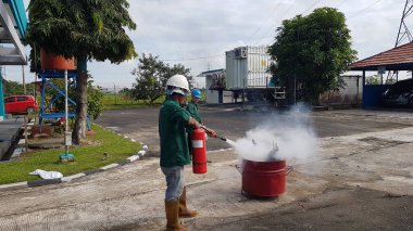 Banjarmasin, Endonezya. 6 Kasım 2021 'de erkekler yangın söndürücüyü kullanarak bir yangın söndürücüyü canlandırdı.