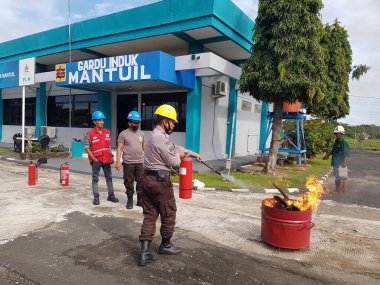 Banjarmasin, Endonezya. 6 Kasım 2021 'de erkekler yangın söndürücüyü kullanarak bir yangın söndürücüyü canlandırdı.