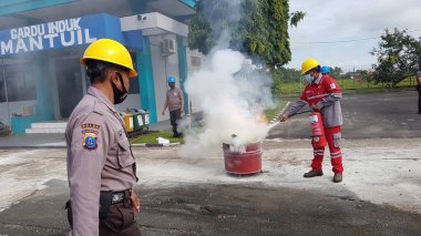 Banjarmasin, Endonezya. 6 Kasım 2021 'de erkekler yangın söndürücüyü kullanarak bir yangın söndürücüyü canlandırdı.