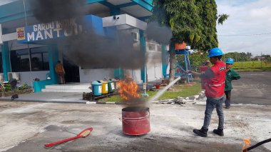Banjarmasin, Endonezya. 6 Kasım 2021 'de erkekler yangın söndürücüyü kullanarak bir yangın söndürücüyü canlandırdı.