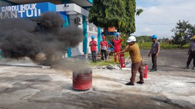 Banjarmasin, Endonezya. 6 Kasım 2021 'de erkekler yangın söndürücüyü kullanarak bir yangın söndürücüyü canlandırdı.