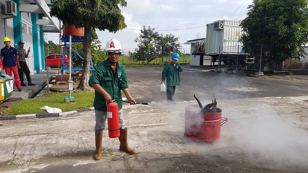 Banjarmasin, Endonezya. 6 Kasım 2021 'de erkekler yangın söndürücüyü kullanarak bir yangın söndürücüyü canlandırdı.