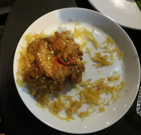 スパイシーなガーリックフライドチキン 黒石の背景にプレート上の甘いと酸味のあるソースでアジアの鶏 トップビュー フラットレイアウト — ストック写真
