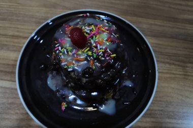 Çikolata soslu leziz çikolatalı pasta ve klasik ahşap masadaki pastane. Seçici odak. 