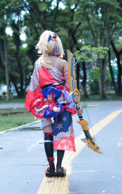 Jakarta, Indonesia - October 29, 2022: Cosplayer girl dressed character from the fantasy video game Genshin Impact Yoimiya at cosplay event.