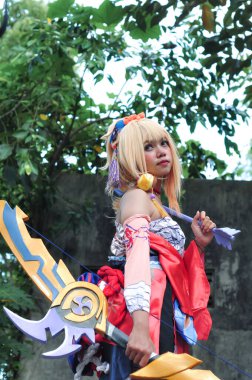 Jakarta, Indonesia - October 29, 2022: Cosplayer girl dressed character from the fantasy video game Genshin Impact Yoimiya at cosplay event.