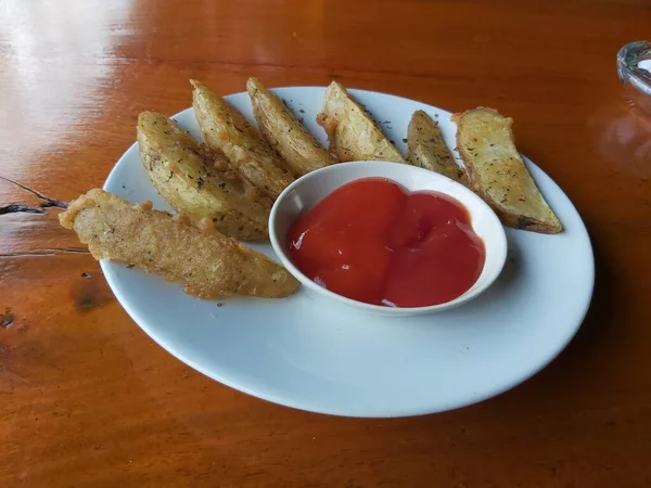 stock image Delicious homemade sweet of roasted organic sweet Wedges potatoes with spices and herbs on a white ceramic plate. on wooden background. Healthy vegetarian food. Restaurant menu