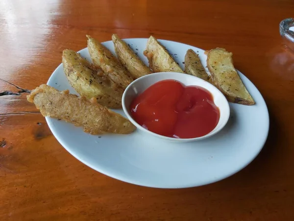 Stock image Delicious homemade sweet of roasted organic sweet Wedges potatoes with spices and herbs on a white ceramic plate. on wooden background. Healthy vegetarian food. Restaurant menu