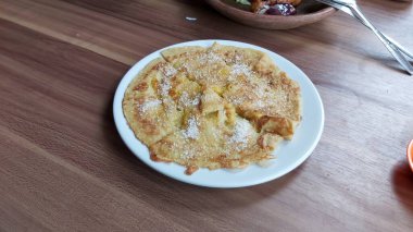 Lempeng Pisang, Güney Kalimantan, Endonezya 'dan geleneksel muzlu krep beyaz tabakta ve ahşap masada servis edilir..