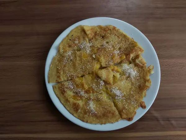 stock image Lempeng Pisang, traditional banana pancake from South Kalimantan, Indonesia Served on white plate and wooden table.