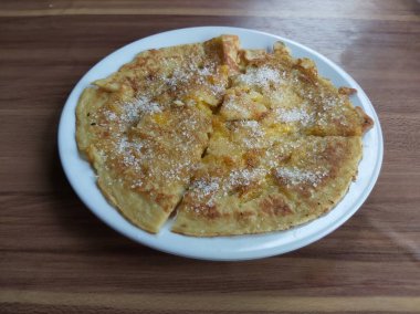 Lempeng Pisang, Güney Kalimantan, Endonezya 'dan geleneksel muzlu krep beyaz tabakta ve ahşap masada servis edilir..