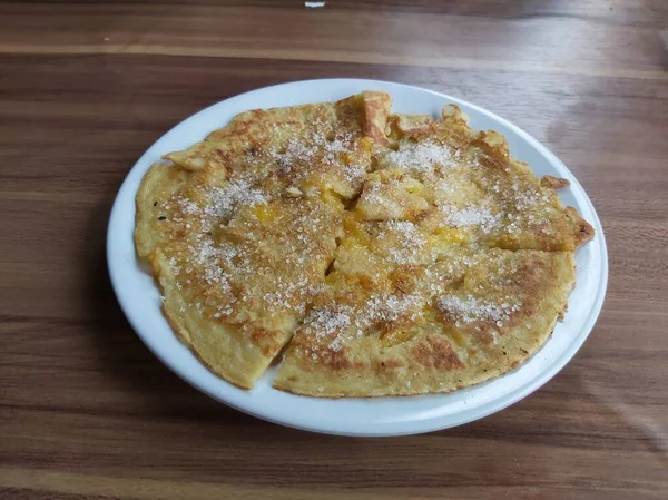 Lempeng Pisang, Güney Kalimantan, Endonezya 'dan geleneksel muzlu krep beyaz tabakta ve ahşap masada servis edilir..