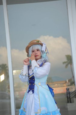 Banjarmasin, Endonezya - 25 Haziran 2023: Kostümlü güzel bir genç kadın oyununun portresi (Cosplayer as Character Kamisato Ayaka) Genshin Impact filminde canlandırılabilir bir Cryo karakteridir.