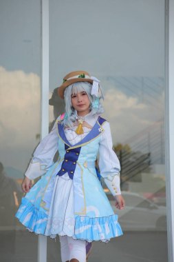 Banjarmasin, Endonezya - 25 Haziran 2023: Kostümlü güzel bir genç kadın oyununun portresi (Cosplayer as Character Kamisato Ayaka) Genshin Impact filminde canlandırılabilir bir Cryo karakteridir.