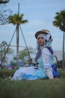 Banjarmasin, Endonezya - 25 Haziran 2023: Kostümlü güzel bir genç kadın oyununun portresi (Cosplayer as Character Kamisato Ayaka) Genshin Impact filminde canlandırılabilir bir Cryo karakteridir.