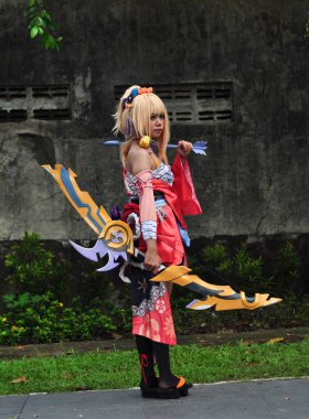 Banjarmasin, Endonezya - 25 Haziran 2023: Kostümlü güzel bir kadın oyununun portresi (Cosplayer as Character Yoimiya) Genshin Impact filminde oynanabilir bir karakterdir. 