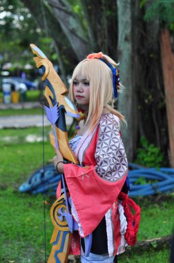 Banjarmasin, Endonezya - 25 Haziran 2023: Kostümlü güzel bir kadın oyununun portresi (Cosplayer as Character Yoimiya) Genshin Impact filminde oynanabilir bir karakterdir. 